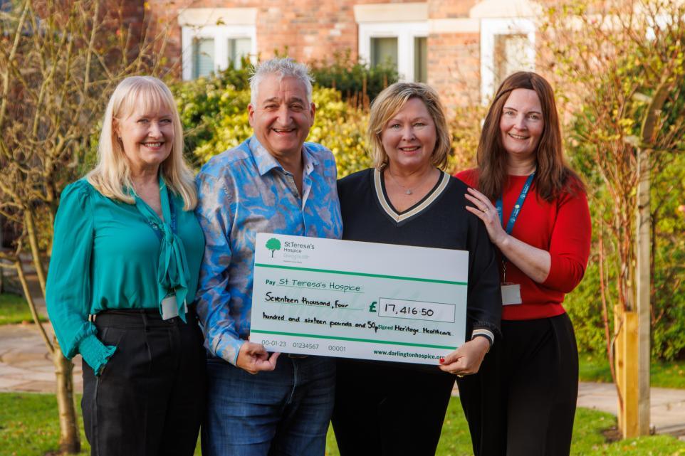 Hospice CEO and Hospice Chair of Trustees both standing with a couple who are holding a cheque addressed to the hospice.